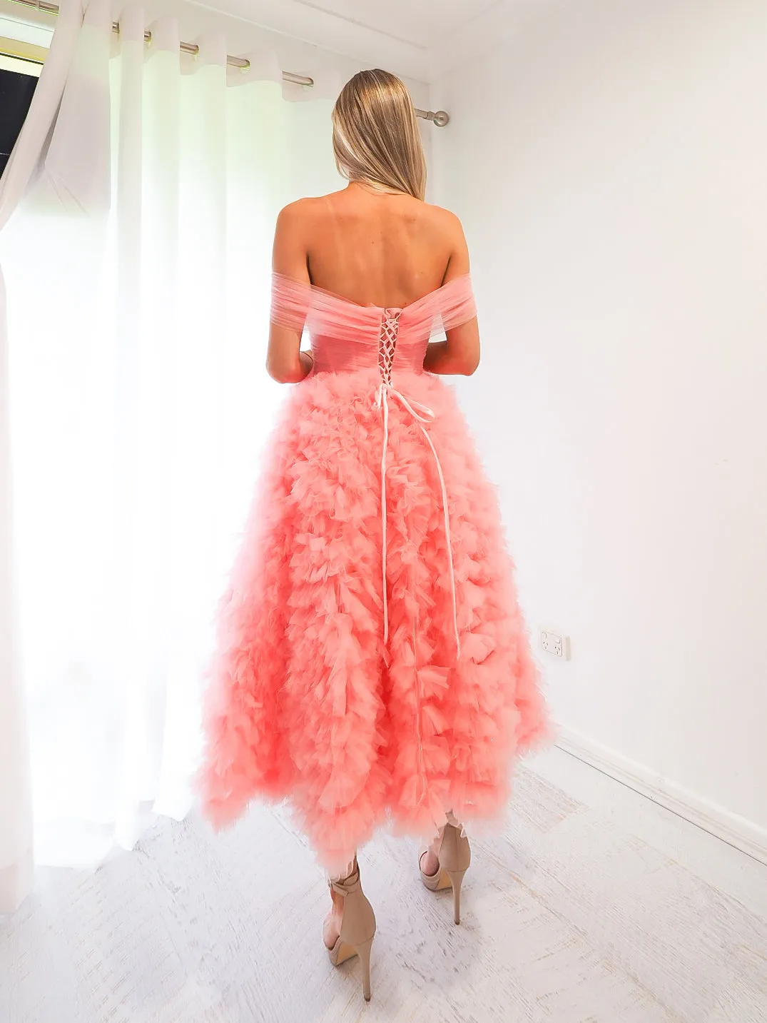 Pastel pink straight neck line with off the shoulder and tulle skirt up to the knees.